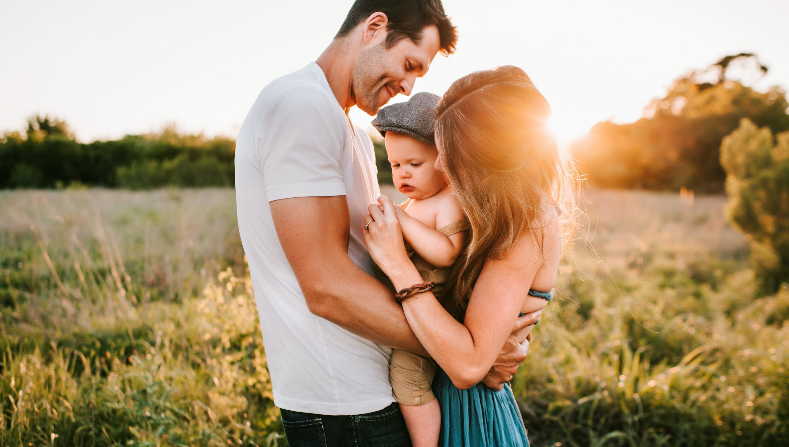 family photo on green grass during golden hour